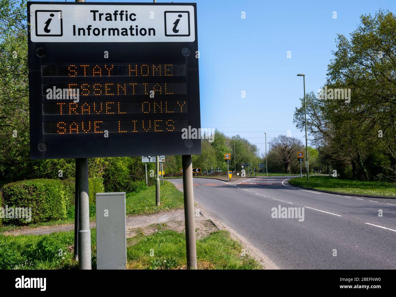 Eine leere Hauptstraße die A336 in Totton, Hampshirte, England, Großbritannien mit einem Sicherheitsschild, das den Fahrern aufzeigt, dass sie „unbedingt nach Hause reisen müssen, nur Leben retten“. Stockfoto
