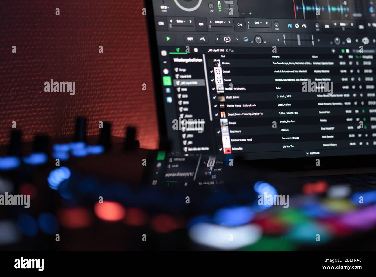 Seitenansicht eines DJ-Laptops mit DJ-Controller im unscharfen Vordergrund Stockfoto