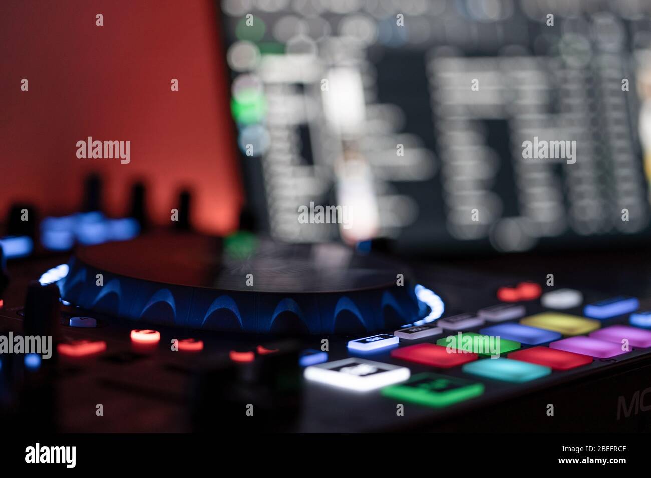 Seitenansicht eines DJ-Controllers mit DJ-Laptop im unscharfen Hintergrund Stockfoto