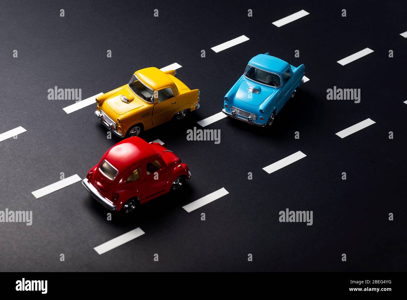 Falsches Überholen von Spielzeug Modell Autos auf einer Straße mit Streifen. Stockfoto
