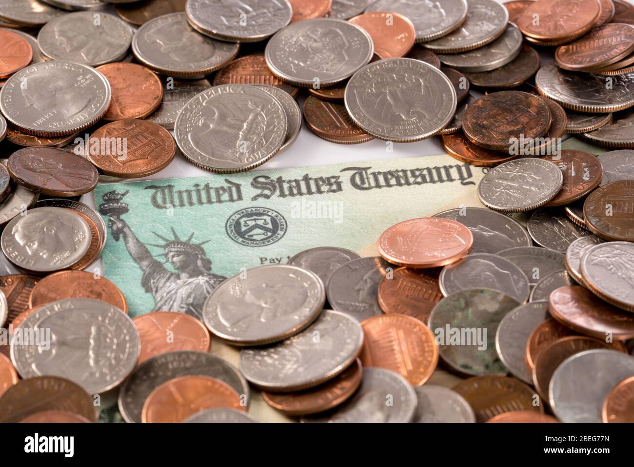 Stapel von losen Wechselgeld und Münzen mit illustrativen Coronavirus Stimulus Zahlung an jeden Bürger Stockfoto