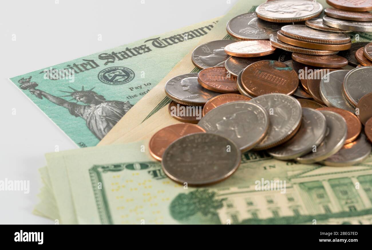 Stapel von 20 Dollar-Scheinen und lose Münzen mit illustrativen Coronavirus Stimulus Zahlung auf weiß Stockfoto