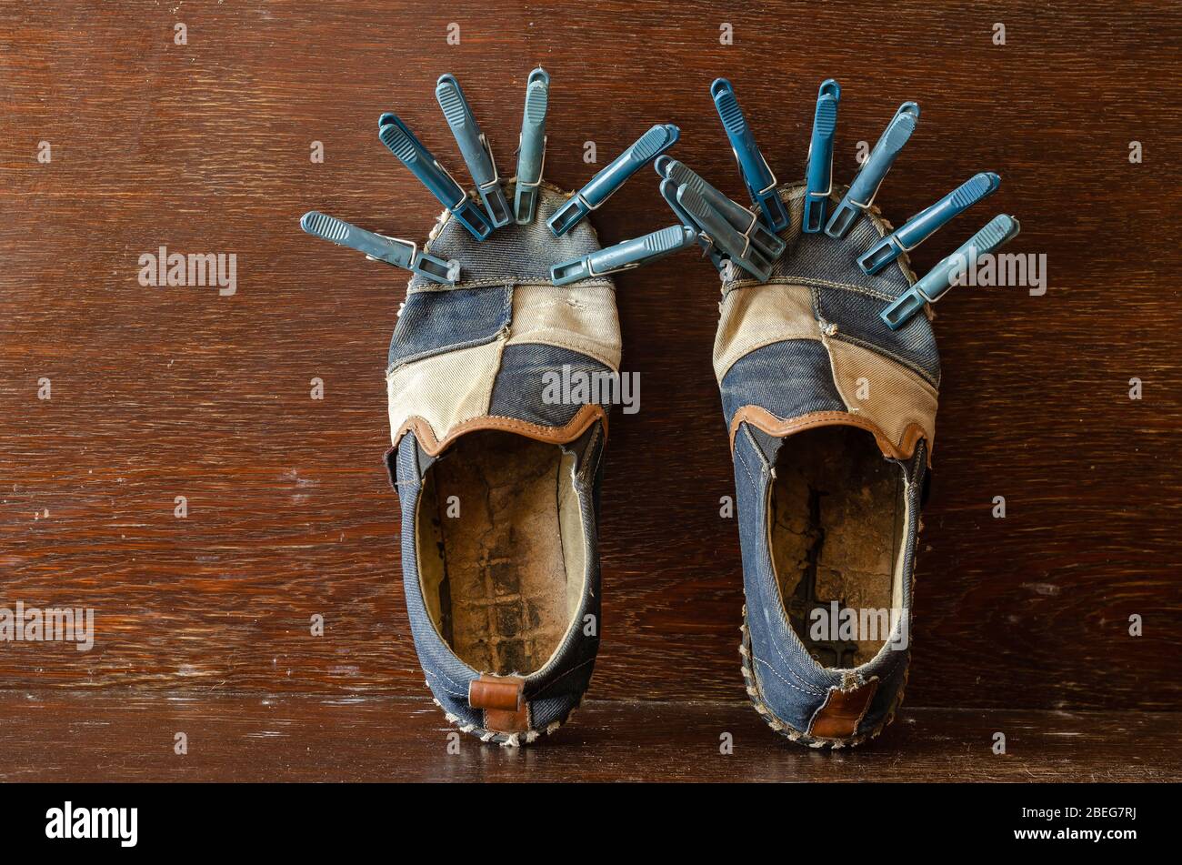 Ein Paar ausgefranste Schuhe mit Wäscheklammern. Alte Schuhe reparieren.  Wäscheklammern halten die geklebte Sohle. Nahaufnahme. Selektiver Fokus  Stockfotografie - Alamy