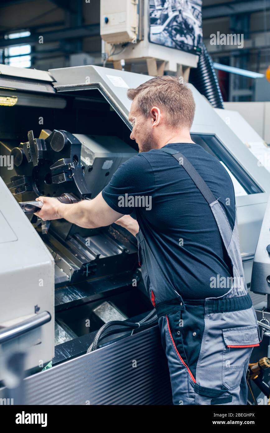 Erfahrener Mitarbeiter, der die Werkzeugeinrichtung der Drehmaschine wechselt Stockfoto