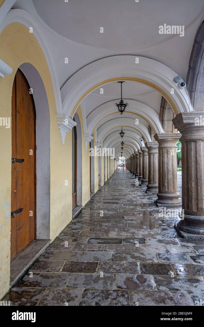 Überdachte Steinbrücke mit Bögen und Säulen eines Kolonialgebäudes neben dem Central Park in Antigua, Guatemala Stockfoto