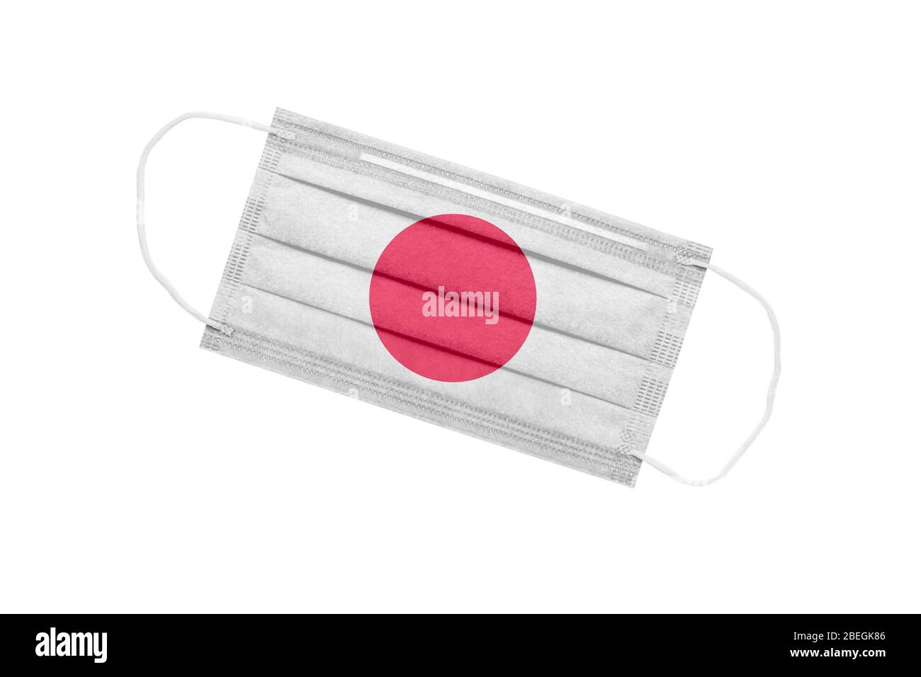 Medizinische Gesichtsmaske mit Flagge von japan isoliert auf weißem Hintergrund. Pandemie-Konzept in japan. Attribut des Coronavirus Ausbruch in Japan. Medizin in Stockfoto