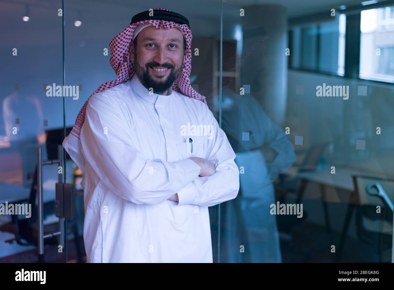 Moderne arabische Geschäftsmann in Tradition Anzug stehen und denken über neue Projekte und Investitionen in die Zukunft. Lächelt in die Kamera. Stockfoto