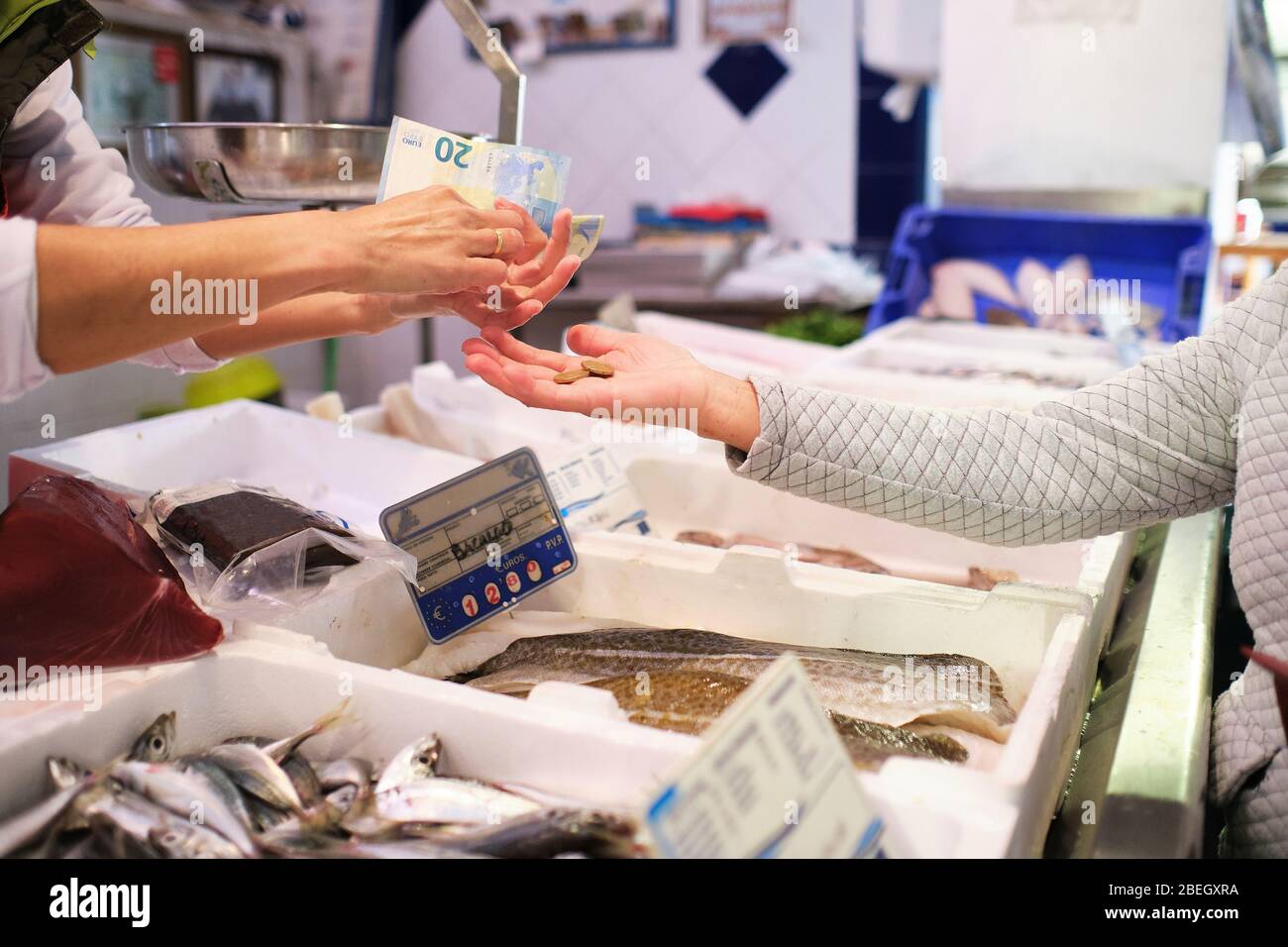Fischhändler Hände, die Geld von seinem Kunden nehmen Stockfoto
