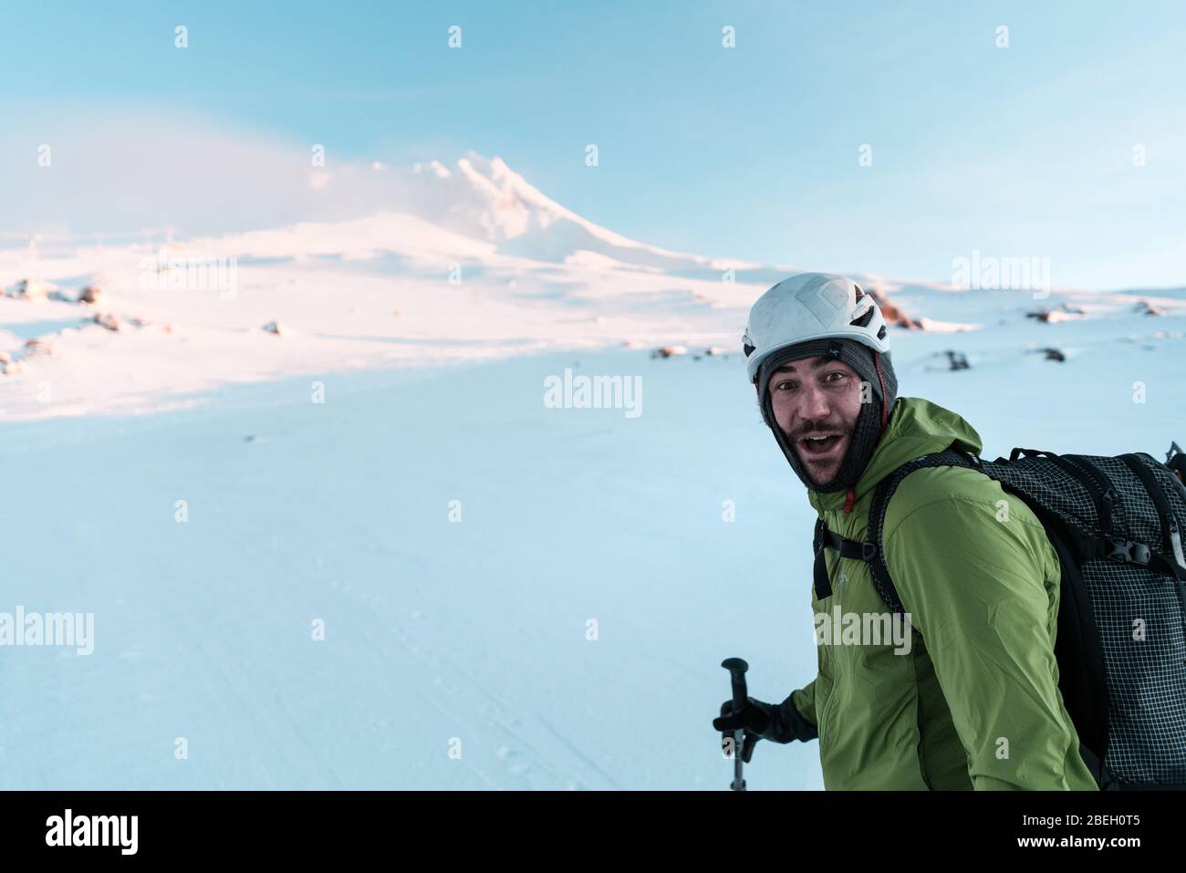Skifahrer, die beim Aufziehen des Berges lächelnd die Kamera betrachten Stockfoto