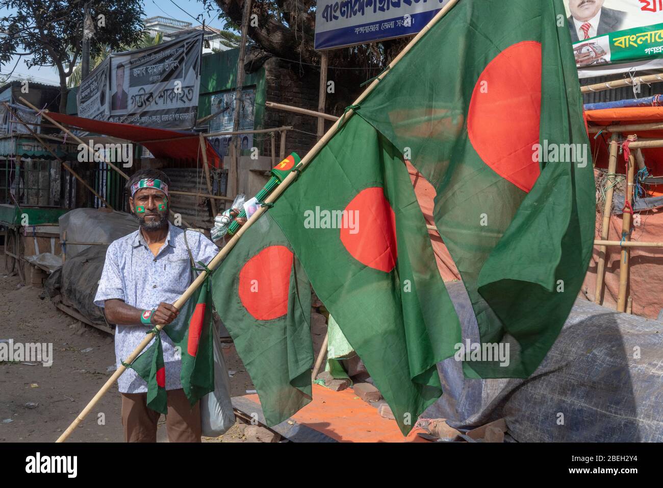 Mann, der Pole mit Bangladesh-Flaggen vor den Wahlen hält, Cox's Bazar Stockfoto