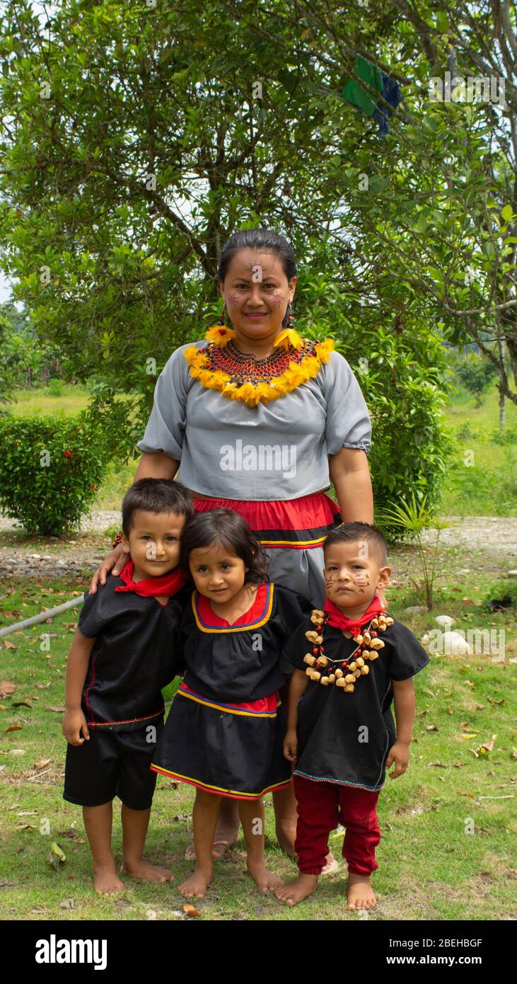 Frau der Cofan-Volksgruppe in ihrer traditionellen Kleidung, die sich um ihre Kinder in der Cofan Dureno-Jahrtausendgemeinschaft kümmert Stockfoto