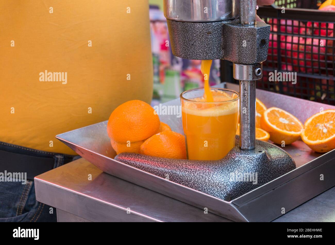 Mechanische Saftpresse. Orangensaft mit der Presse-Maschine machen. Objekt der Lebensmittelindustrie Stockfotografie