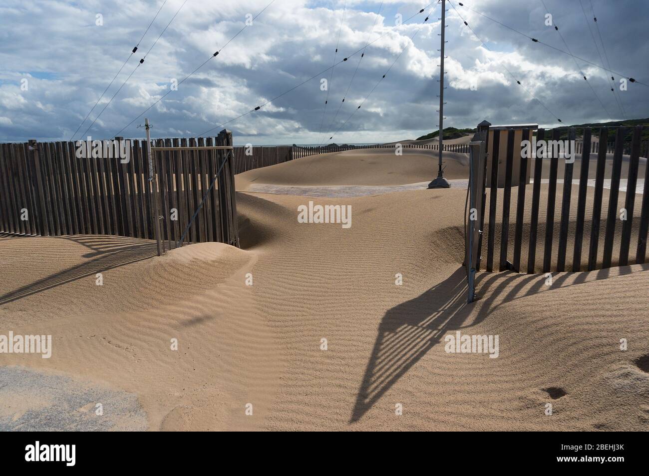 Sanddüne dringt ins Land ein. Wüstenbildung durch Klimawandel und Übererkundung. Szene mit Umweltproblemen Stockfoto