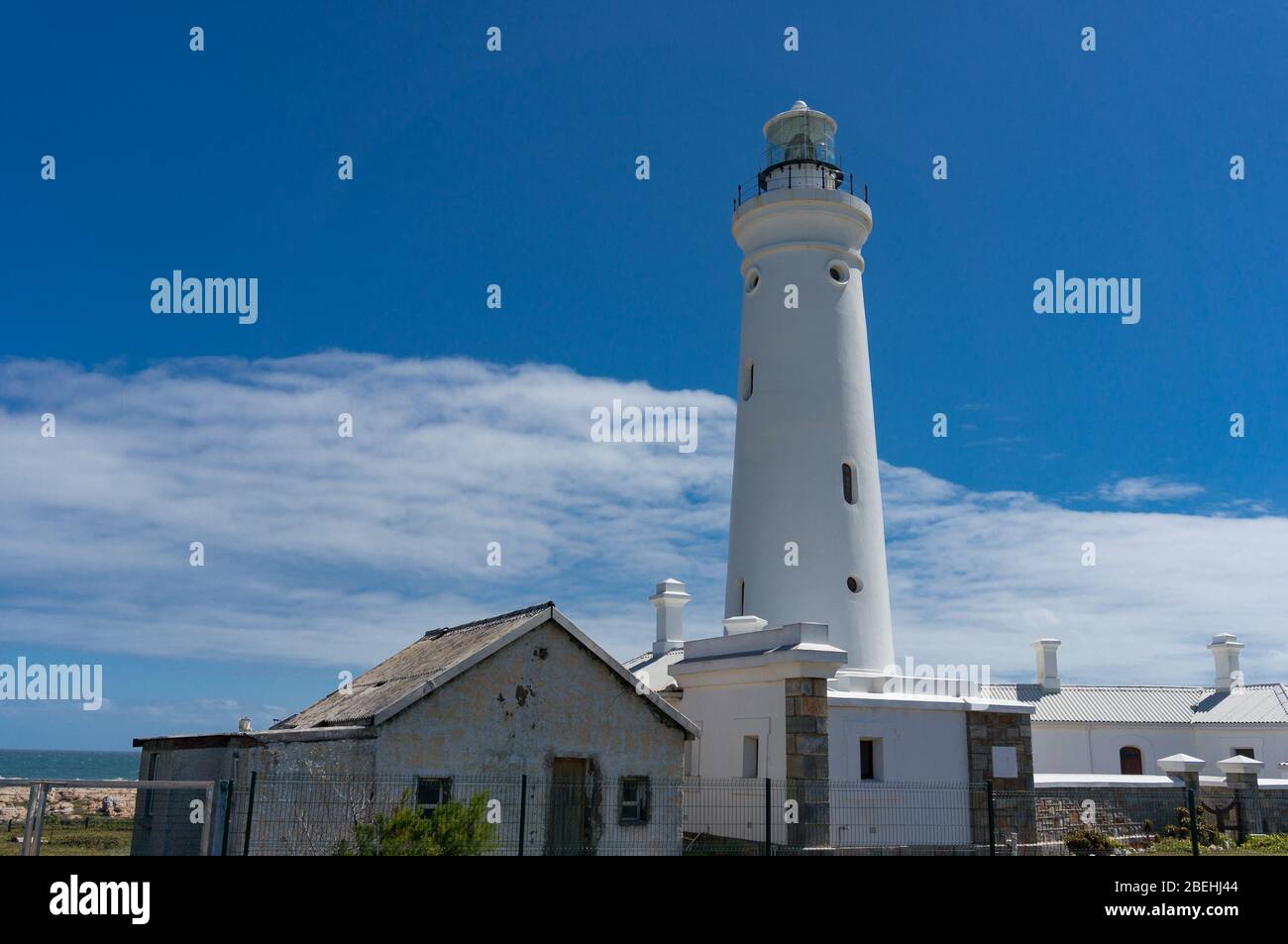 Heller weißer Leuchtturm gegen blauen Himmel an sonnigen Tag. Wahrzeichen des Seal Point Lighthouse am Cape St Francis in Südafrika Stockfoto