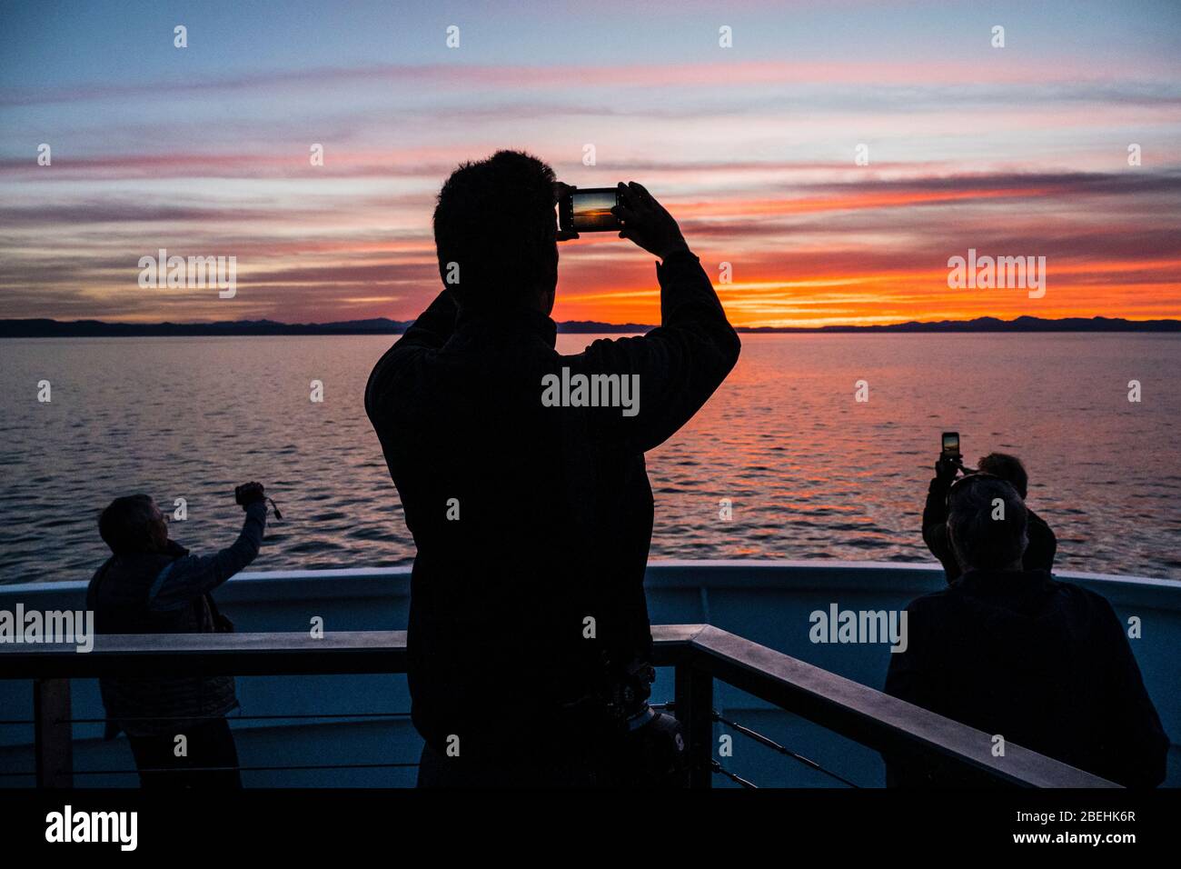 Touristen fangen einen wunderschönen Sonnenuntergang vor Isla San Marcos, Baja California Sur, Mexiko. Stockfoto