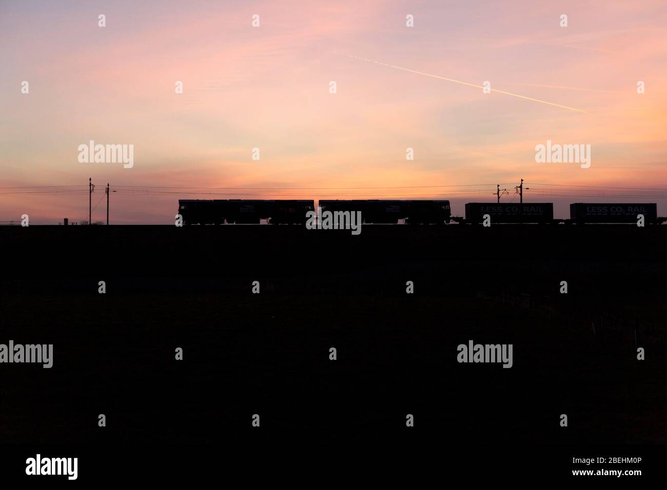 2 DRS-Lokomotiven der Baureihe 66, die den intermodalen Containerfrachtzug Stobart Less co2 auf der Westküstenlinie, Großbritannien bei Sonnenuntergang transportieren Stockfoto