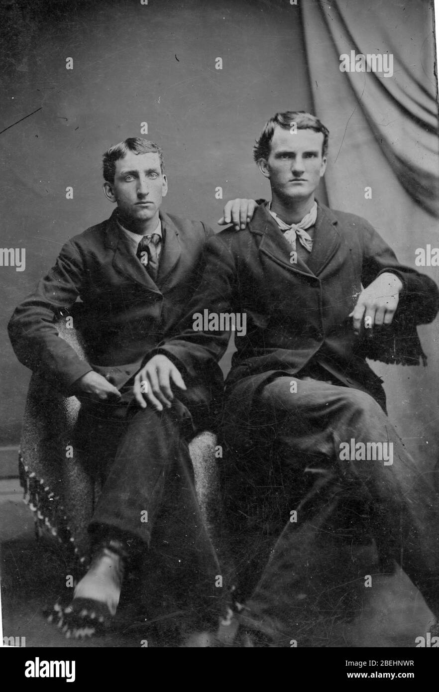 Zwei Männer, die in den 1860er Jahren nebeneinander in einem Fotostudio saßen. Sie sind offensichtlich nah beieinander und hübsch gekleidet. Die Krawatte eines Mannes ist schlecht gebunden, während der andere ein Halstuch um den Hals hat. Sind sie ein liebevolles Paar, Brüder? Freunde? Schwul? Um alle meine Bilder zu sehen, Suche Prestor Vintage Gay Stockfoto