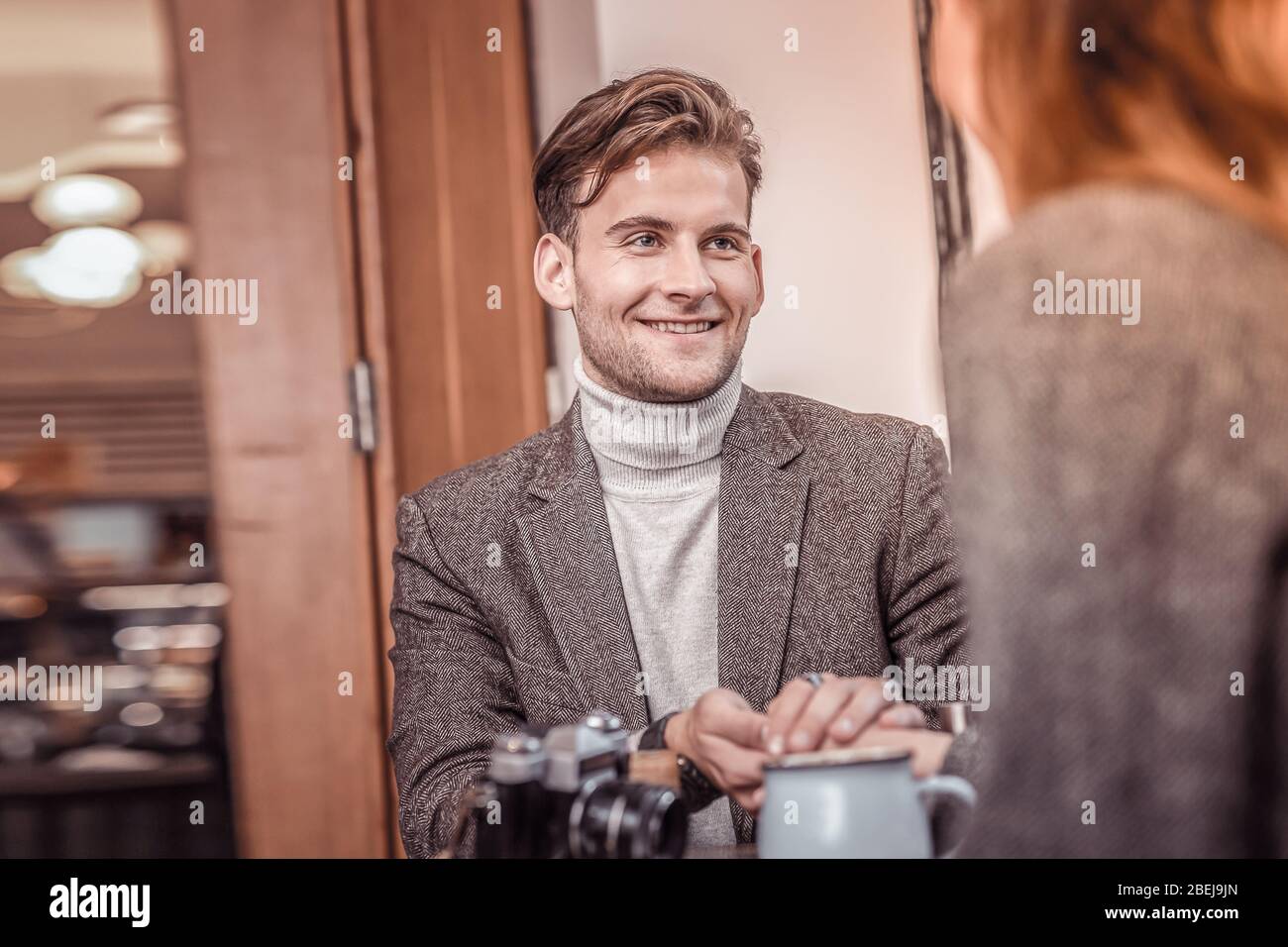 Konzentrieren Sie sich auf einen schönen Mann in der Suite, der die Hände mit der Frau im Café hält Stockfoto