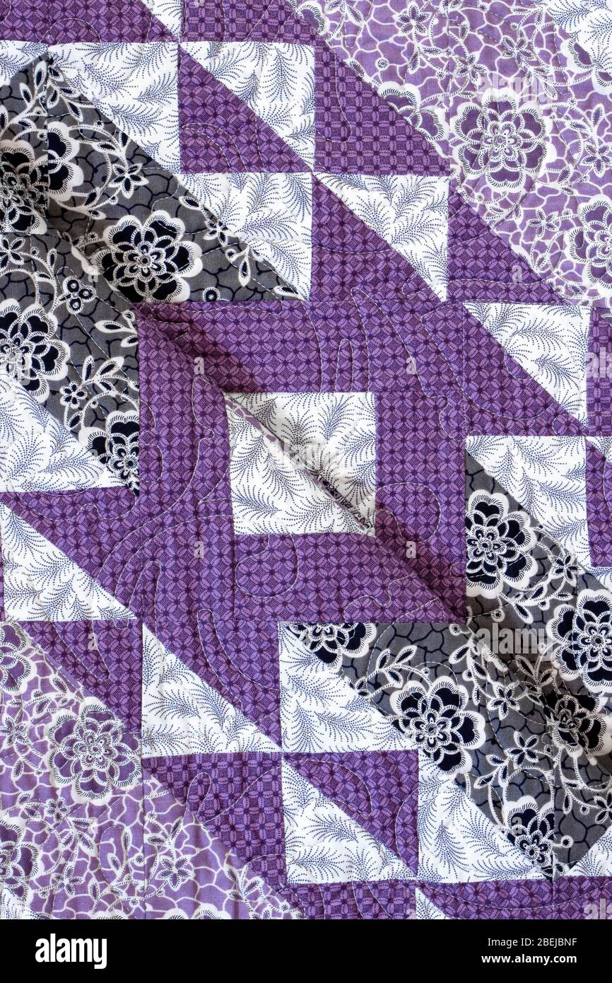 Lila farbige handgemachte Patchwork-Bett Quilt mit verschiedenen Stoff geometrischen Designs Stockfoto