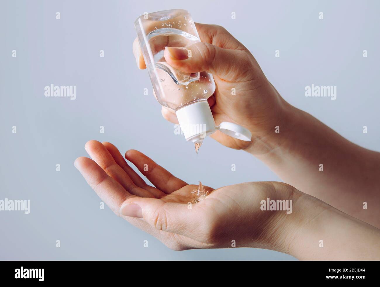 Nahaufnahme der Frau mit einem kleinen tragbaren antibakteriellen Handdesinfektionsmittel an den Händen. Stockfoto
