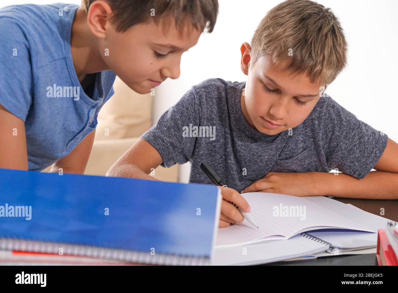 Lernen zu Hause, Fernunterricht, Online-Lernen. Kinder zu Hause Hausaufgaben mit Büchern Notizbücher und denken, wie man mathematische Aufgaben zu machen Stockfoto