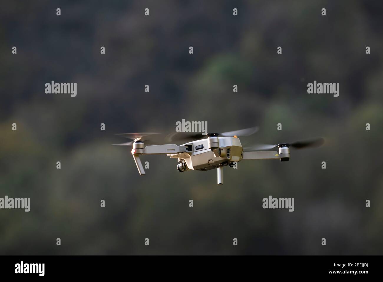 Drohne im Flug, im Vordergrund, mit Videokamera, umgeben von Natur Stockfoto