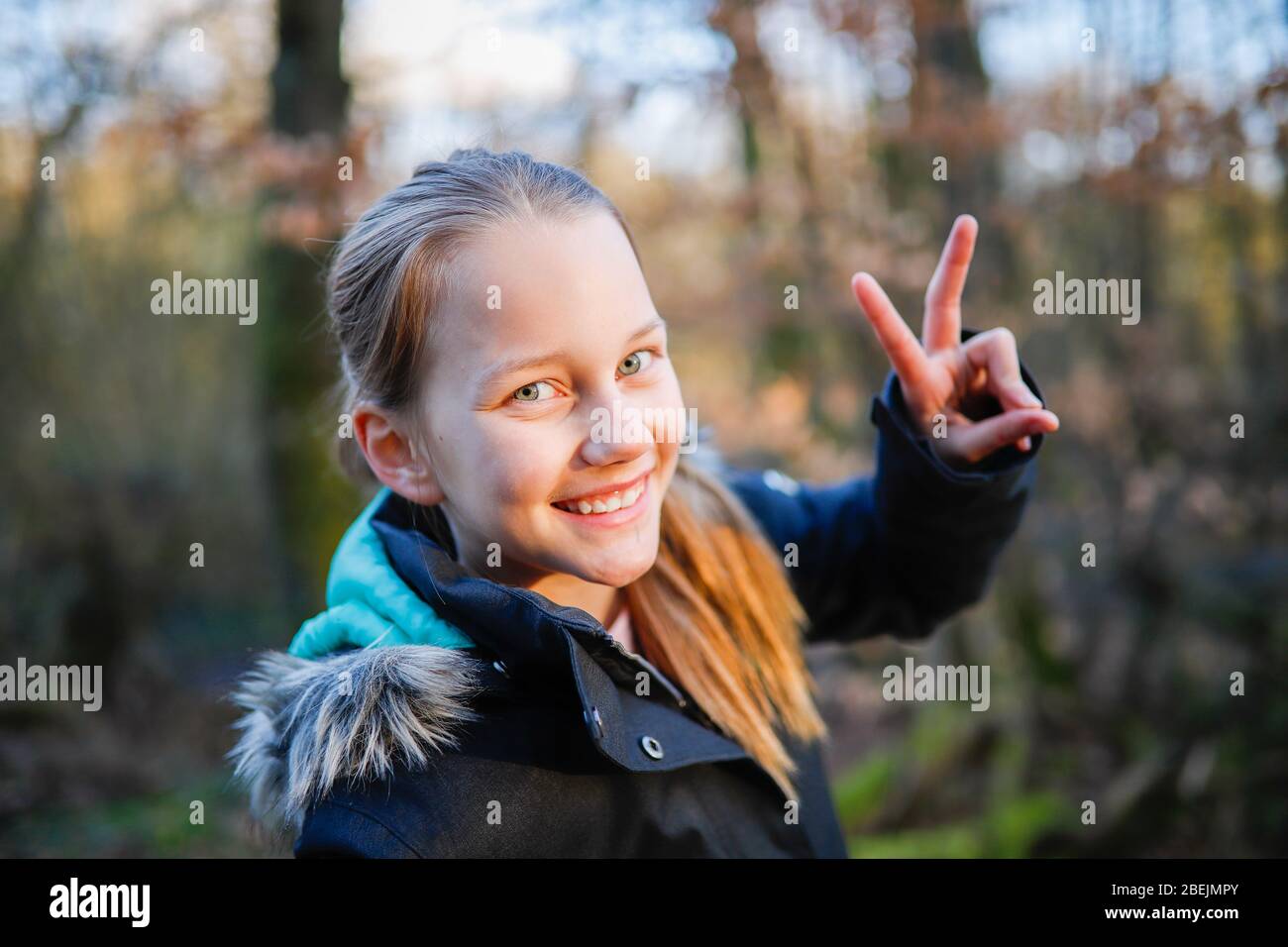 Ein Mädchen zeigt mit den Fingern ein Siegeszeichen Stockfoto
