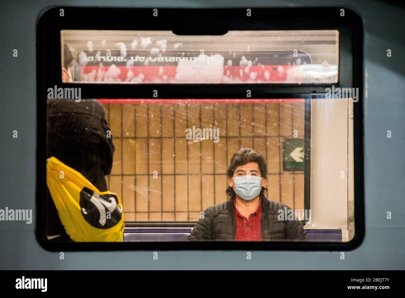 Barcelona, Katalonien, Spanien. 14. Apr 2020 - EIN Pendler mit einer schützenden Gesichtsmaske wird in einem U-Bahn-Wagen am Bahnhof Catalunya in Barcelona gesehen. Tausende von Menschen kehren zur Arbeit zurück, nachdem die spanische Regierung die strengsten Maßnahmen der Coronavirus-Haft aufzuheben hat. Quelle: Jordi Boixareu/Alamy Live News Stockfoto
