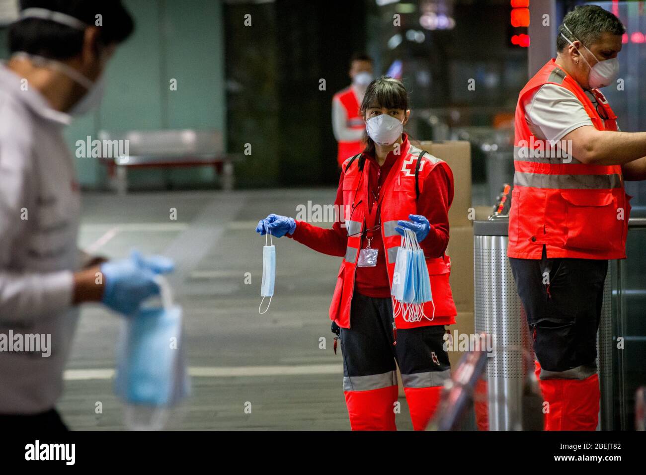 Barcelona, Katalonien, Spanien. 14. Apr 2020 - Freiwillige des Roten Kreuzes halten schützende Gesichtsmasken, um sie an der Station Catalunya in Barcelona unter Pendlern zu verteilen. Tausende von Menschen kehren zur Arbeit zurück, nachdem die spanische Regierung die strengsten Maßnahmen der Coronavirus-Haft aufzuheben hat. Quelle: Jordi Boixareu/Alamy Live News Stockfoto