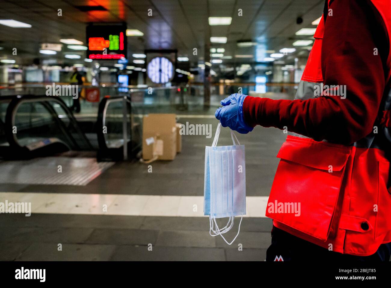 Barcelona, Katalonien, Spanien. 14. Apr 2020 - EIN Freiwilliger des Roten Kreuzes hält schützende Gesichtsmasken, um sie an der Station Catalunya in Barcelona unter Pendlern zu verteilen. Tausende von Menschen kehren zur Arbeit zurück, nachdem die spanische Regierung die strengsten Maßnahmen der Coronavirus-Haft aufzuheben hat. Quelle: Jordi Boixareu/Alamy Live News Stockfoto