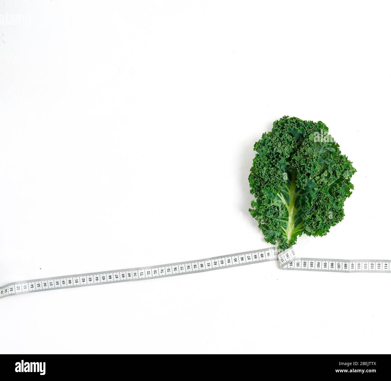 Kale eingewickelt in Maßband, Konzept Diät, Abnehmen, gesunde Ernährung, oben Stockfoto