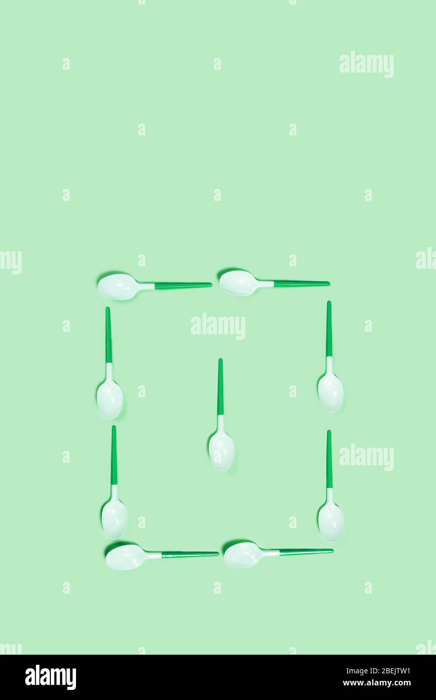 Abbildung der weißen Kunststofflöffel auf blauem Hintergrund. Flache Lage, Draufsicht. Flaches Layout, Draufsicht, Kopierbereich. Stockfoto