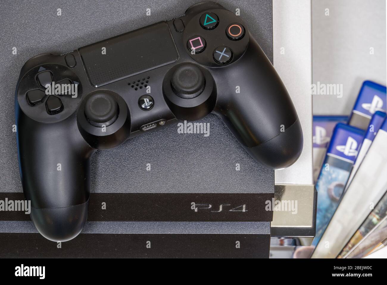PlayStation 4 DualShock 4 Wireless-Controller – Draufsicht. Gamepad, das über der Sony Spielekonsole mit Logo steht. Stockfoto