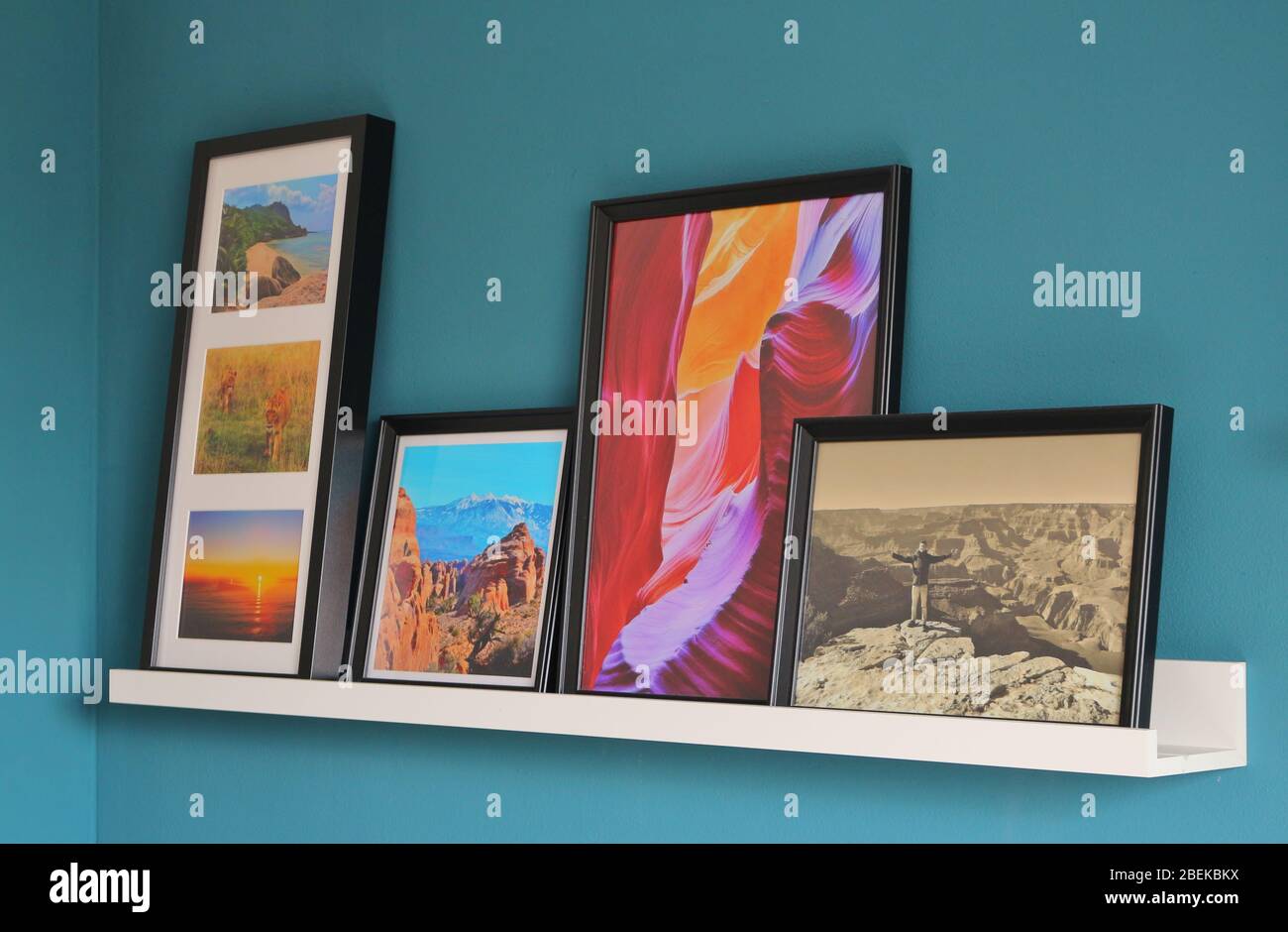 Genießen Sie einen Rückweg zu guten Reiseerinnerungen Foto von Bildern mit Reiseszenen, die eine Geschichte erzählen.die Bilder stehen auf einem Regal an einer Wand. Stockfoto