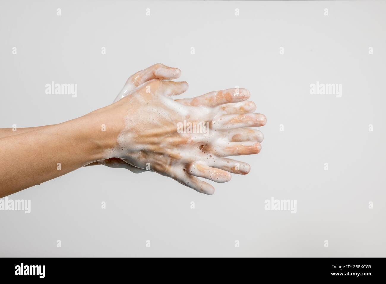 Nahaufnahme der kaukasischen Frau, die ihre Hände auf weißem Hintergrund isoliert wäscht. Vorführung des Händewaschens. Konzept der Hygiene und Prävention coronavir Stockfoto