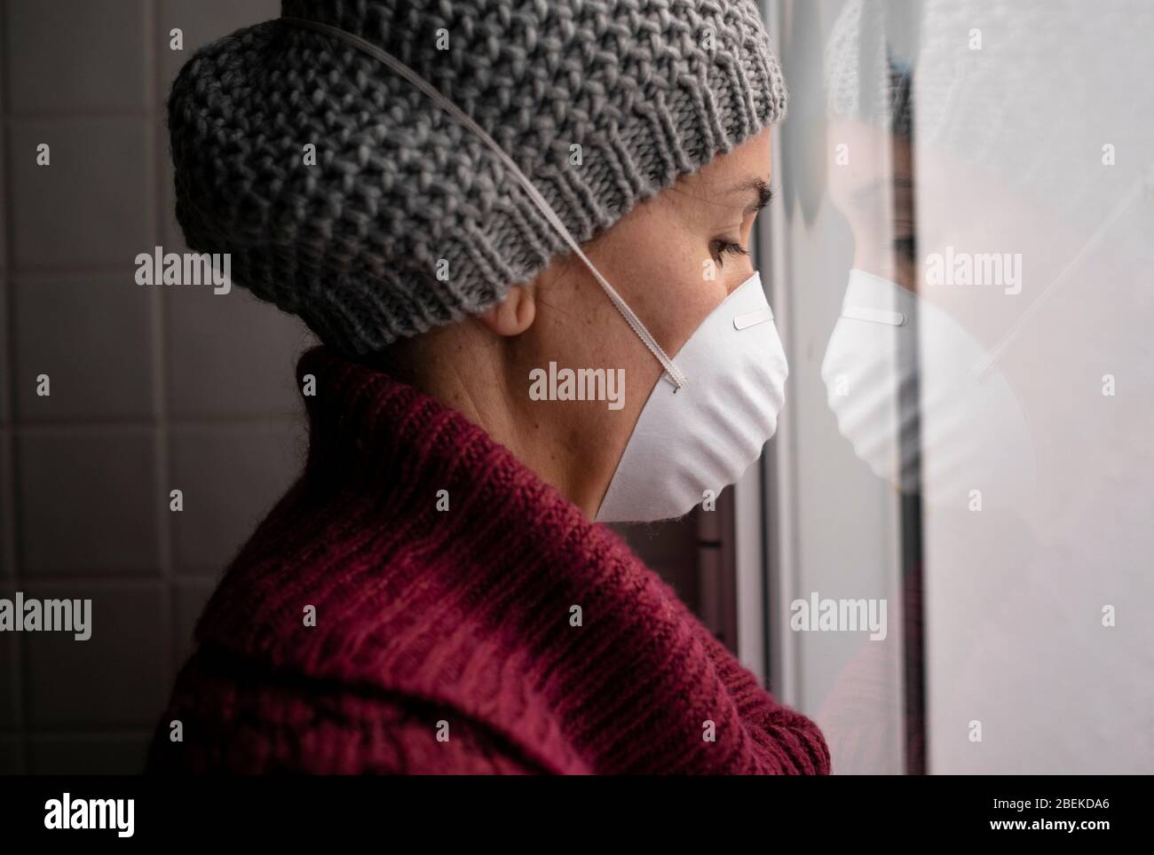 Frau mit Gesichtsmasken drinnen zu Hause, Corona-Virus und Quarantäne-Konzept Stockfoto