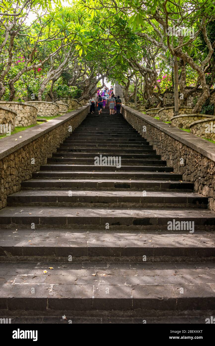 Vertikale Ansicht von Menschen, die die Treppe zum Uluwatu-Tempel in Bali, Indonesien, hinaufgehen. Stockfoto
