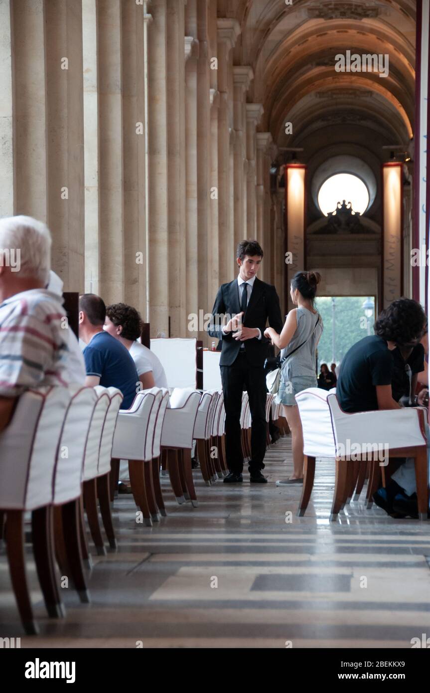 Paris, Frankreich - Juli 08 2008: Leute und Kellner in einem raffinierten Café in der Rue de Rivoli, das Le Café Marly, beim Louvre-Museum heißt Stockfoto