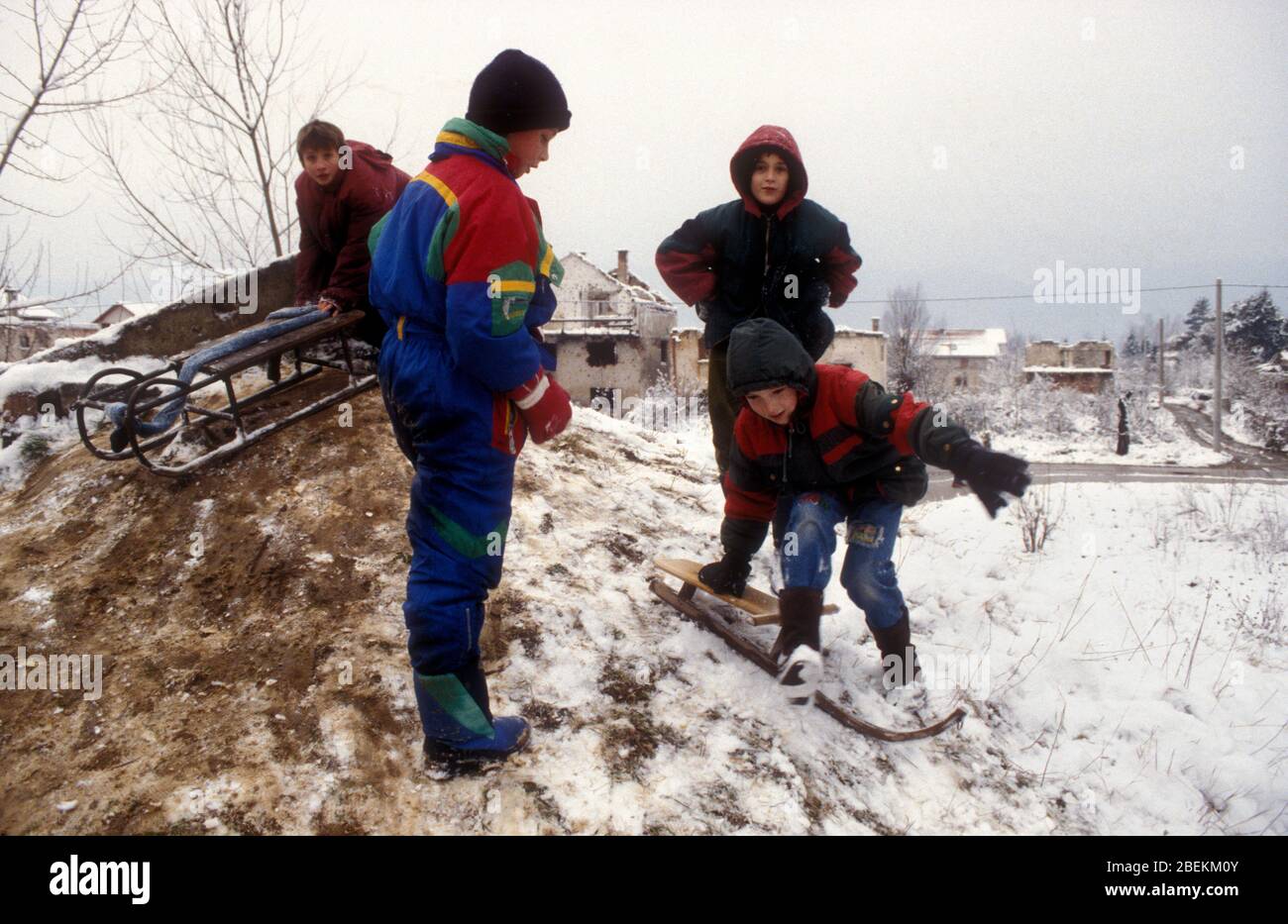 Sarajevo 1995 - Kinder spielen im Schnee in Wohngebiet, das von serbischen Bombenangriffen während der Belagerung von Sarajevo, Bosnien und Herzegowina getroffen wurde Stockfoto