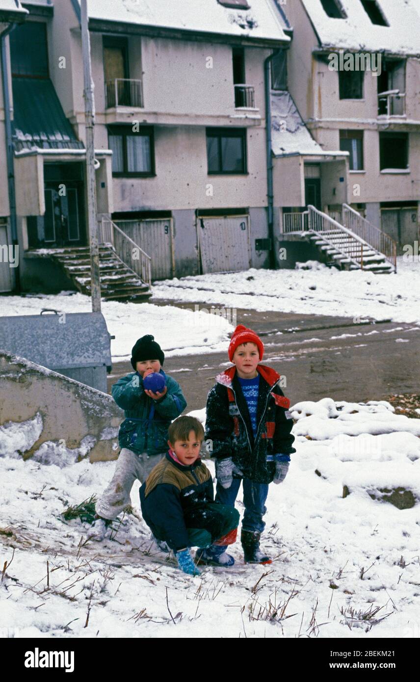 Sarajevo 1995 - Kinder spielen im Schnee in Wohngebiet, das von serbischen Bombenangriffen während der Belagerung von Sarajevo, Bosnien und Herzegowina getroffen wurde Stockfoto