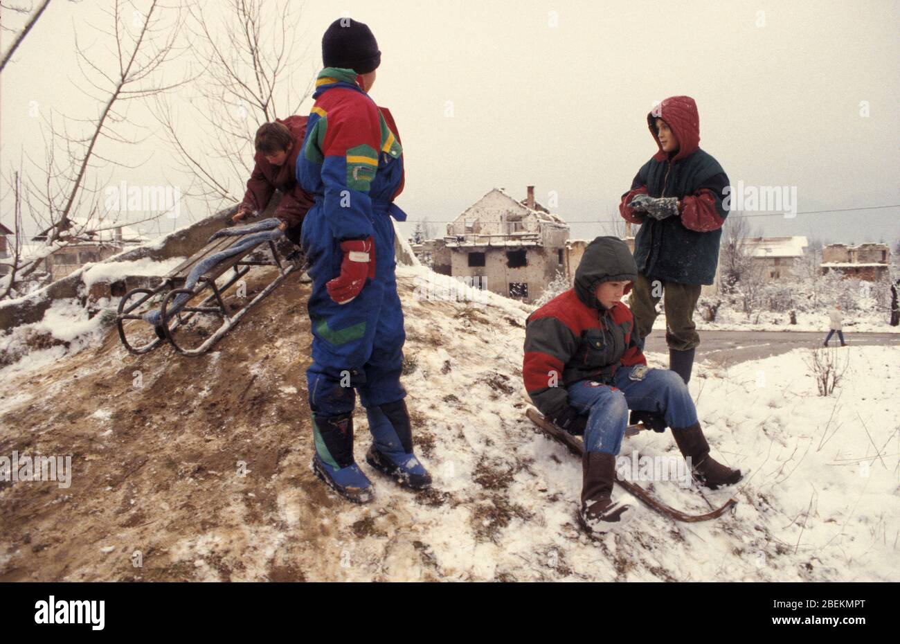 Sarajevo 1995 - Kinder spielen im Schnee in Wohngebiet, das von serbischen Bombenangriffen während der Belagerung von Sarajevo, Bosnien und Herzegowina getroffen wurde Stockfoto