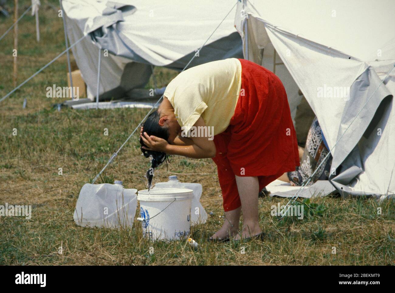 1995 - Frau, die sich auf dem Flugplatz Tuzla Haare wäscht, ein temporäres UN-Flüchtlingslager für bosnische Muslime, die vor dem Massaker von Srebrenica während des Bosnienkrieges fliehen Stockfoto