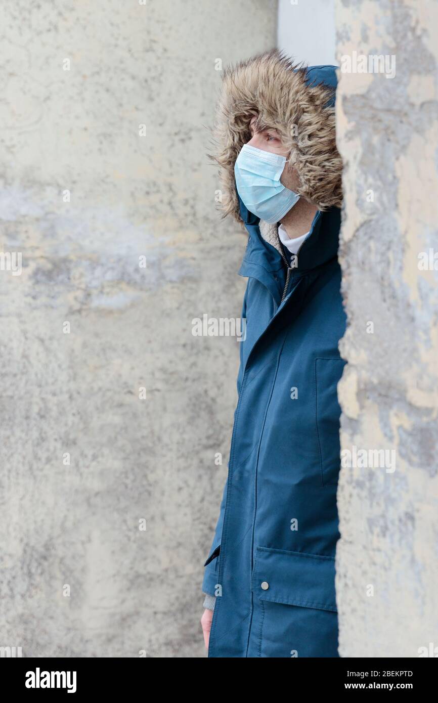 Ungesunder Mann mit Kapuze trägt Einwegschutzmaske gegen übertragbare Infektionskrankheiten und als Schutz gegen Grippe oder Coronaviru Stockfoto Ungesunder Mann mit Kapuze trägt Einwegschutzmaske gegen übertragbare Infektionskrankheiten und als Schutz gegen Grippe oder Coronaviru Stockfoto