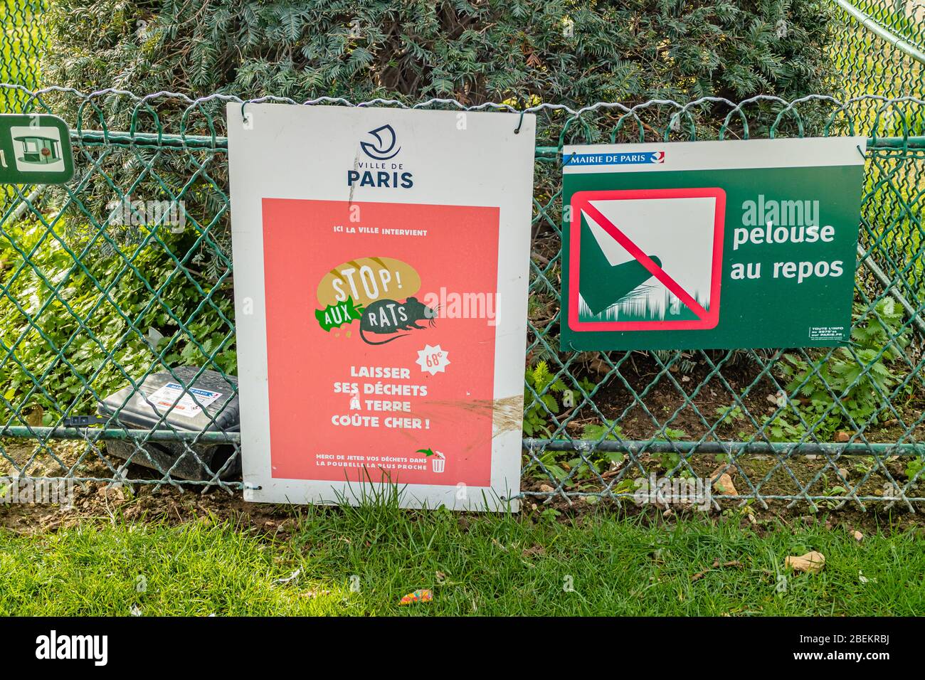 Auf Französisch sind Schilder angebracht, die den Leuten sagen, dass sie das Gras nicht wegwerfen und keinen Abfall fallen lassen sollen, da es Ratten anzieht. Champ de Mars Park, Paris, Frankreich. Februar 2020. Stockfoto