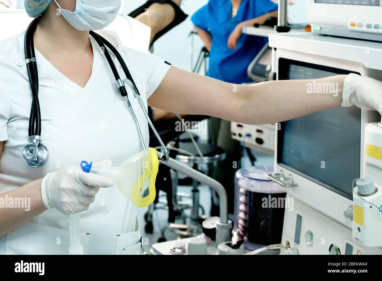 Ein Intensivarzt bereitet bei einem kritischen Patienten mit Coronavirus Geräte für die künstliche Beatmung der Lunge für die Intubation vor. COVID-19 Stockfoto