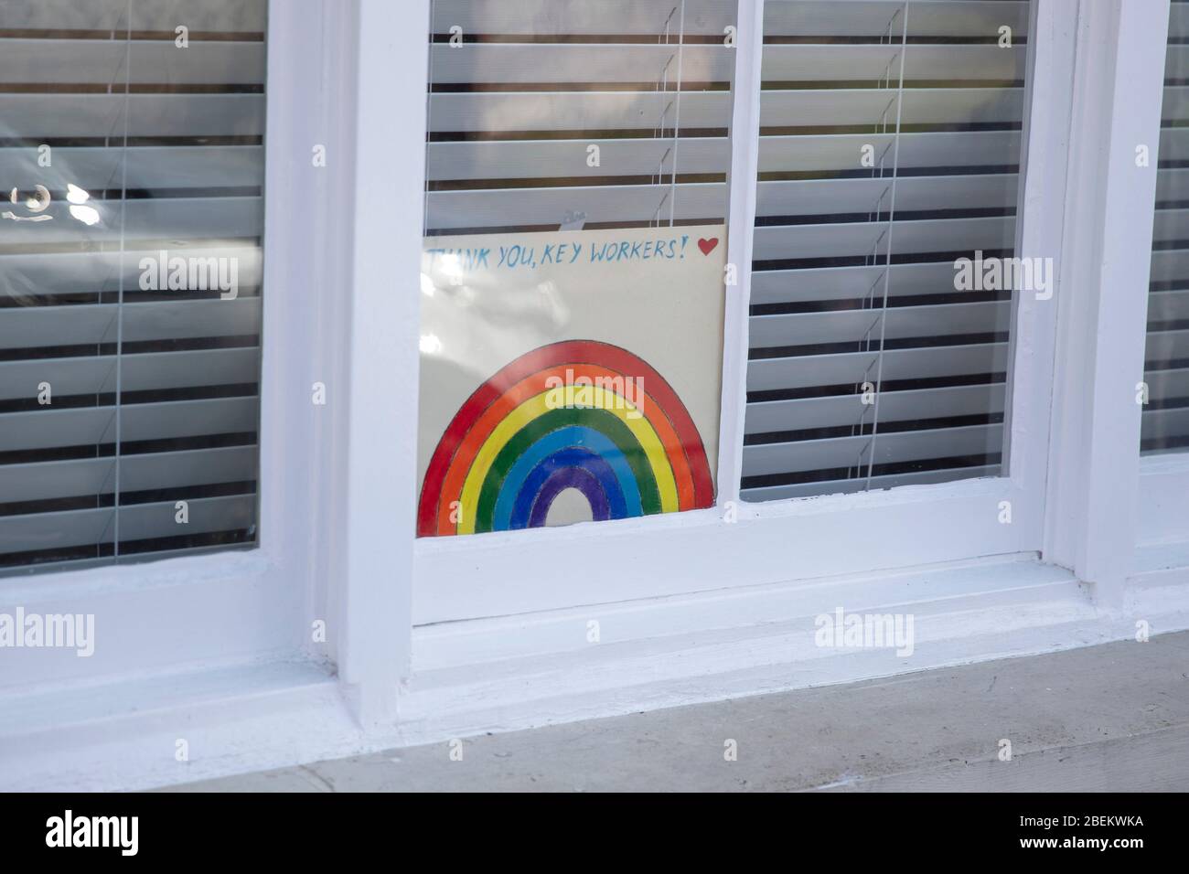 Danke Schlüsselarbeiter Regenbogen-Nachricht in einem Fenster während des Coronavirus Ausbruch Stockfoto