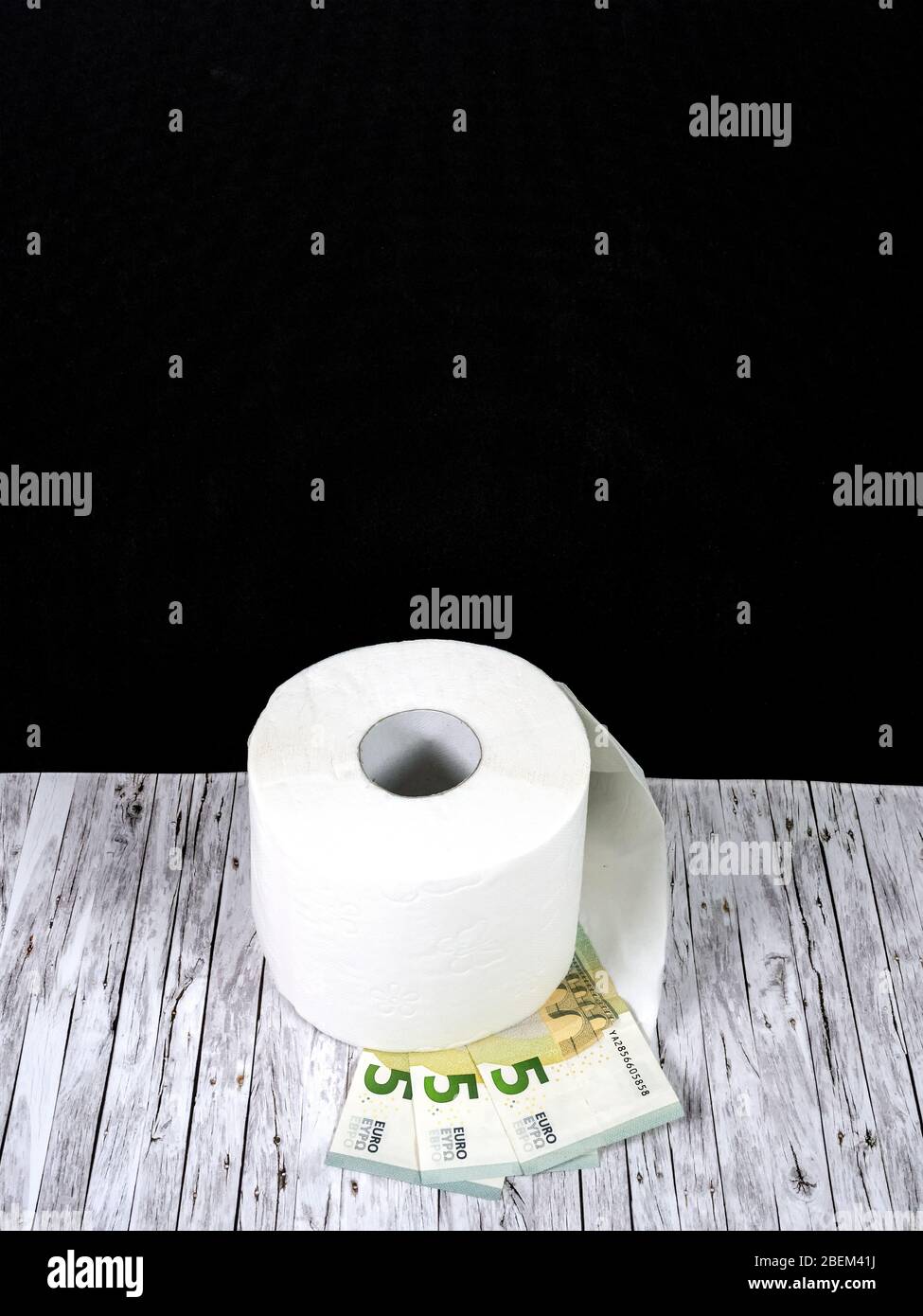 Eine Rolle weißes Toilettenpapier und drei fünf-Euro-Banknoten Stockfoto