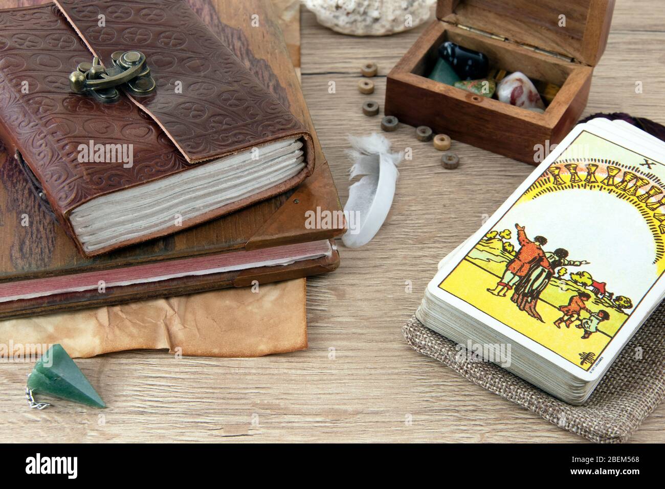 Tarot Karten, Holzbuch und Schachtel auf braunem Brett Stockfoto
