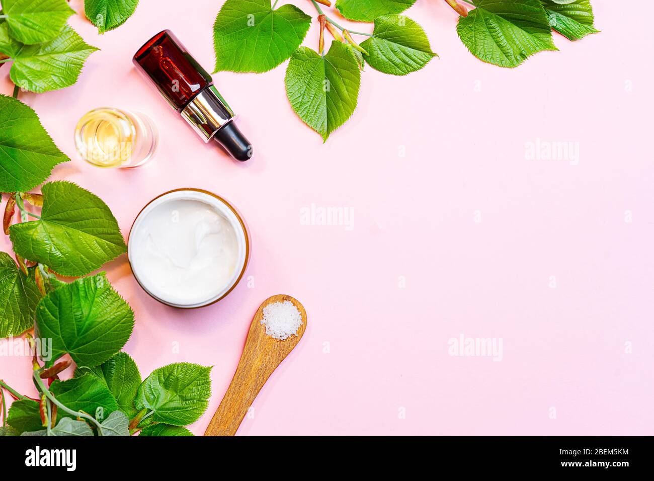 Hautpflegeprodukte, natürliche Kosmetik. Flaches Lay-Bild auf rosa Hintergrund. Natürliche kosmetische Hautpflege Flasche, Serum und Bio-grünes Blatt. Hausgemachte und Beauty-Produkt-Konzept. Stockfoto