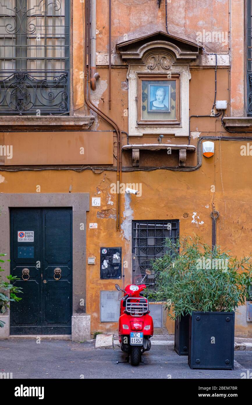 Straßen roms, berühmte rote Vespa, Motorroller in der Vicolo Doria Gasse, Madonnelle Bild, Jungfrau Maria Bild, Rom, Italien. Stockfoto